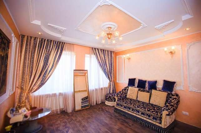 Роскошный диван и шторы в персиково-синей цветовой палитре