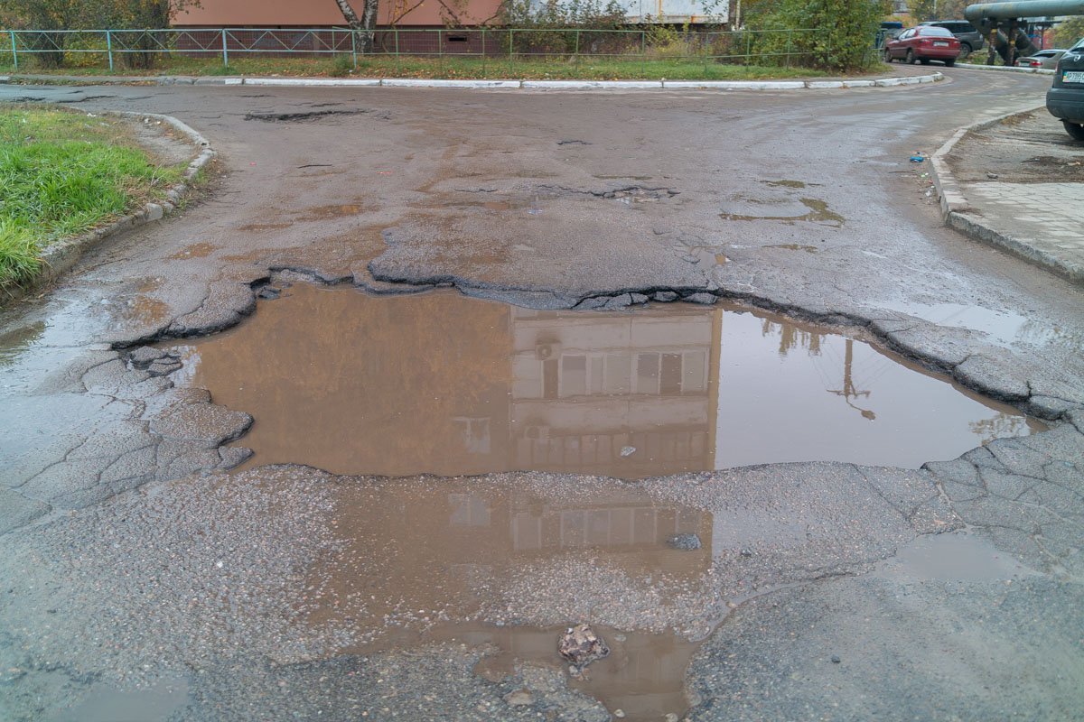 Из-за разбитого асфальта образовались огромные лужи