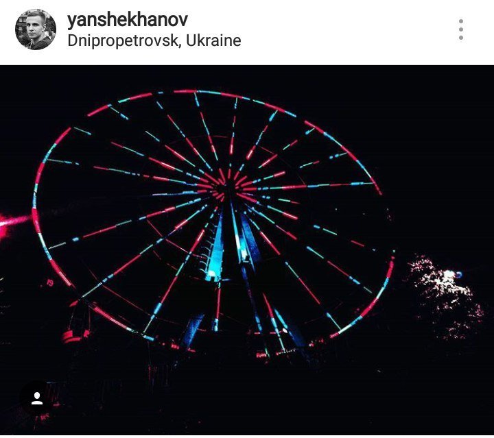 Колесо обозрения ночью сияет разными красками