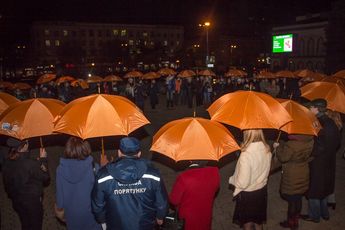 Участники акции "разорвали" сложенный из оранжевых зонтиков круг - символическое изображение проблемы гендерного насилия Участники акции "разорвали" сложенный из оранжевых зонтиков круг - символическое изображение проблемы гендерного насилия