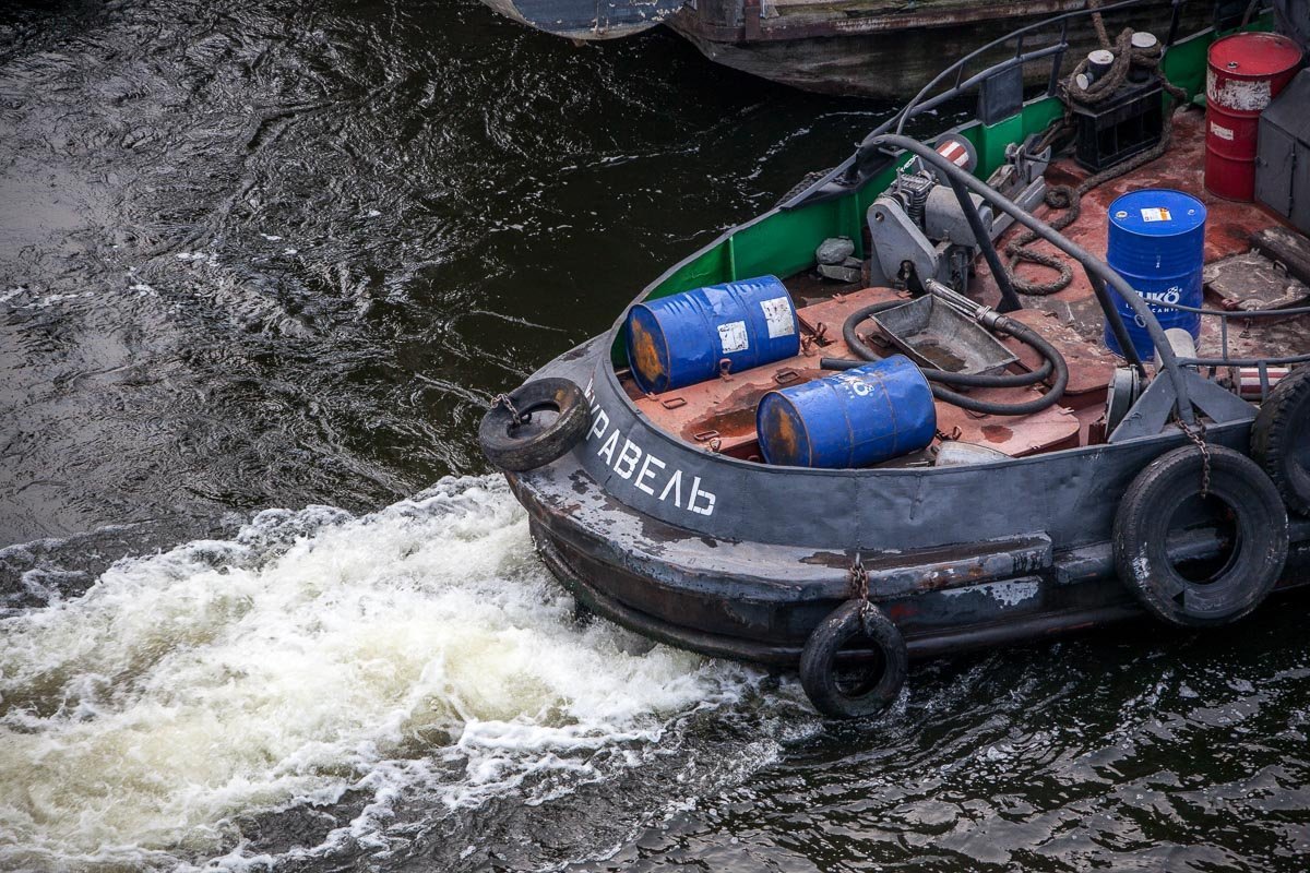 Баржу увозят два буксира
