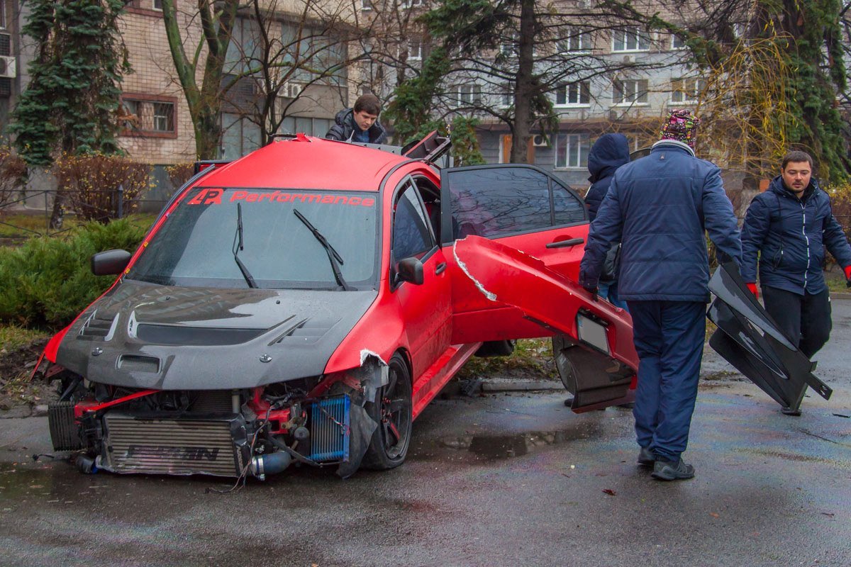 Друзья водителя помогают собрать части авто