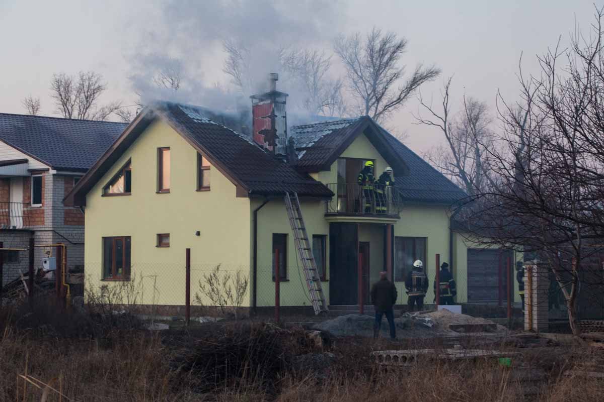 Используя лестницу, спасатели залезли на крышу дома и начали тушить пожар Используя лестницу, спасатели залезли на крышу дома и начали тушить пожар