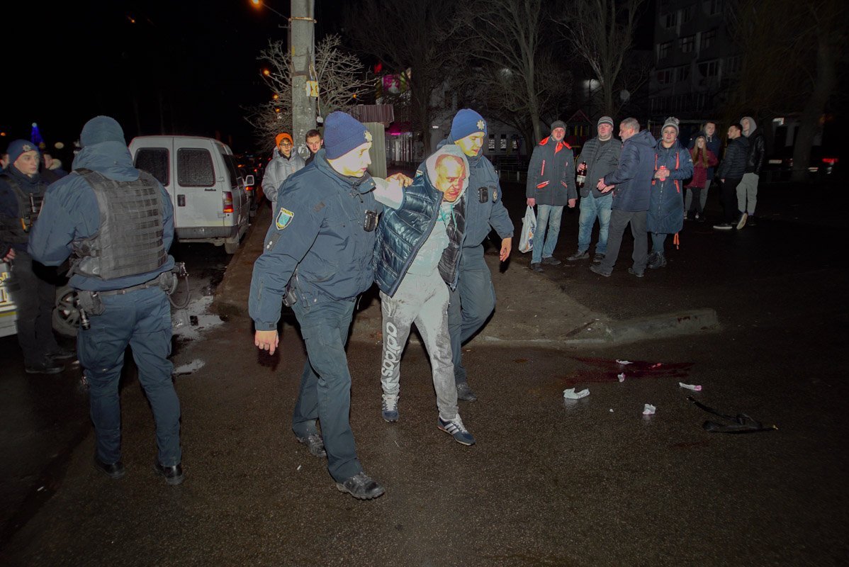 Злоумышленника заковали в наручники и посадили в патрульную машину Злоумышленника заковали в наручники и посадили в патрульную машину