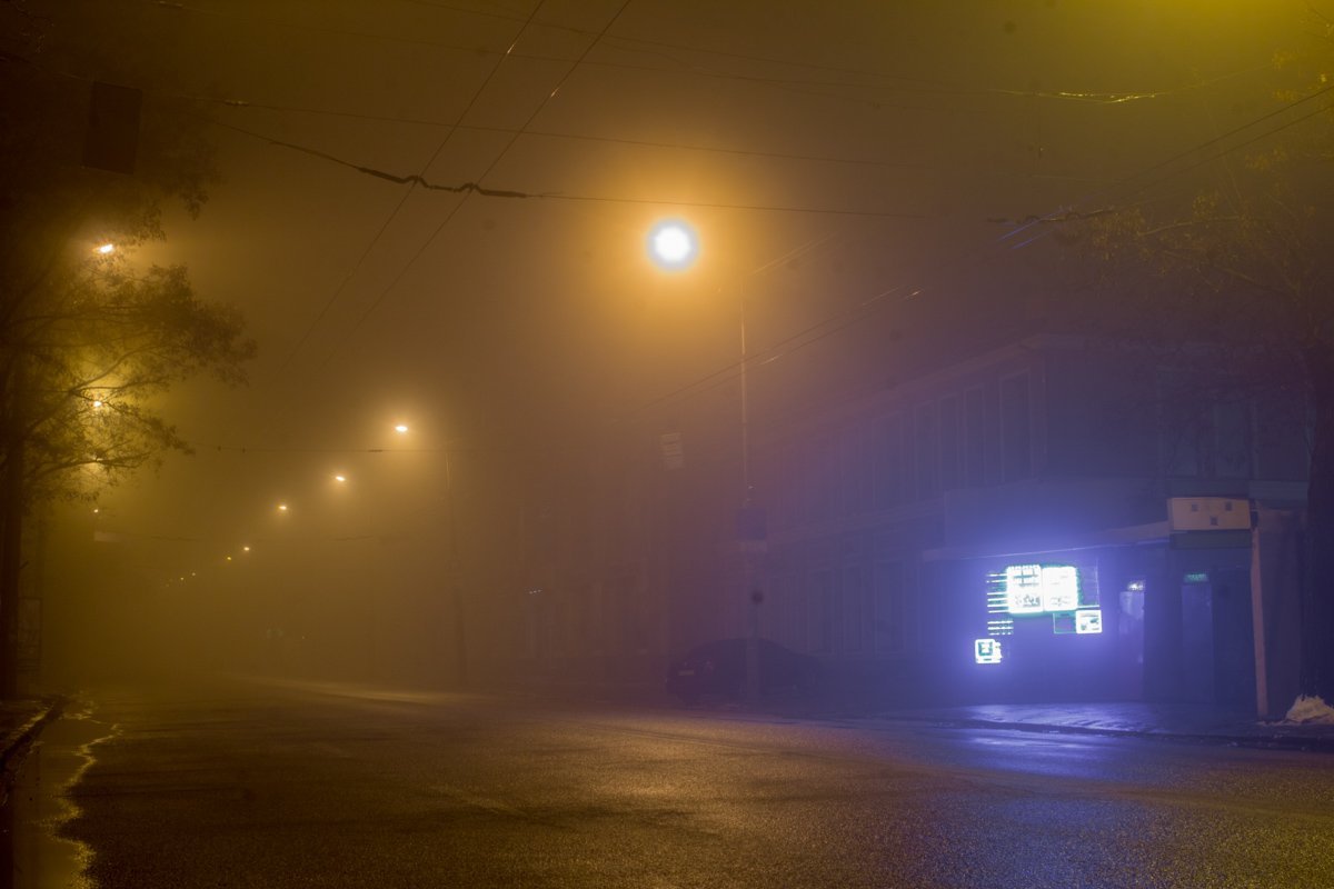 Свет от уличных фонарей и неоновых вывесок растворяется в воздухе