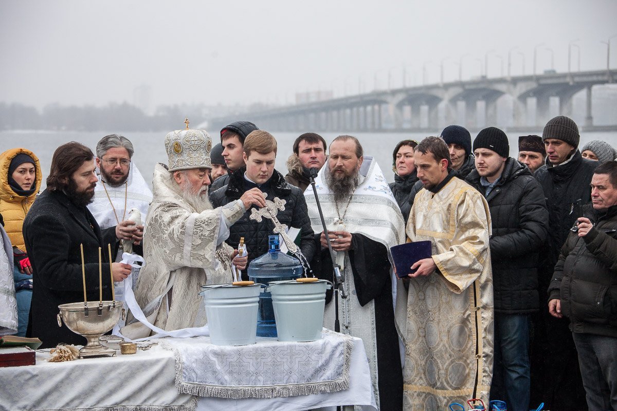 Митрополит Ириней окунает крест в священную воду Митрополит Ириней окунает крест в священную воду