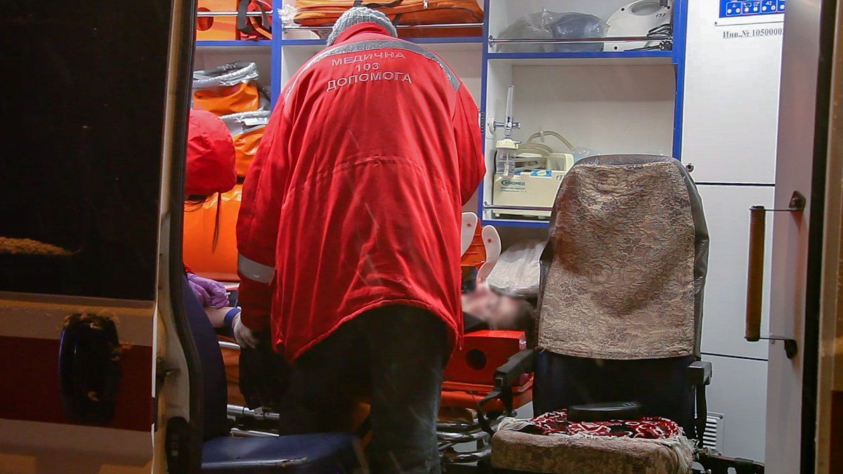 Врачи оказывают первую медицинскую помощь пострадавшему в аварии