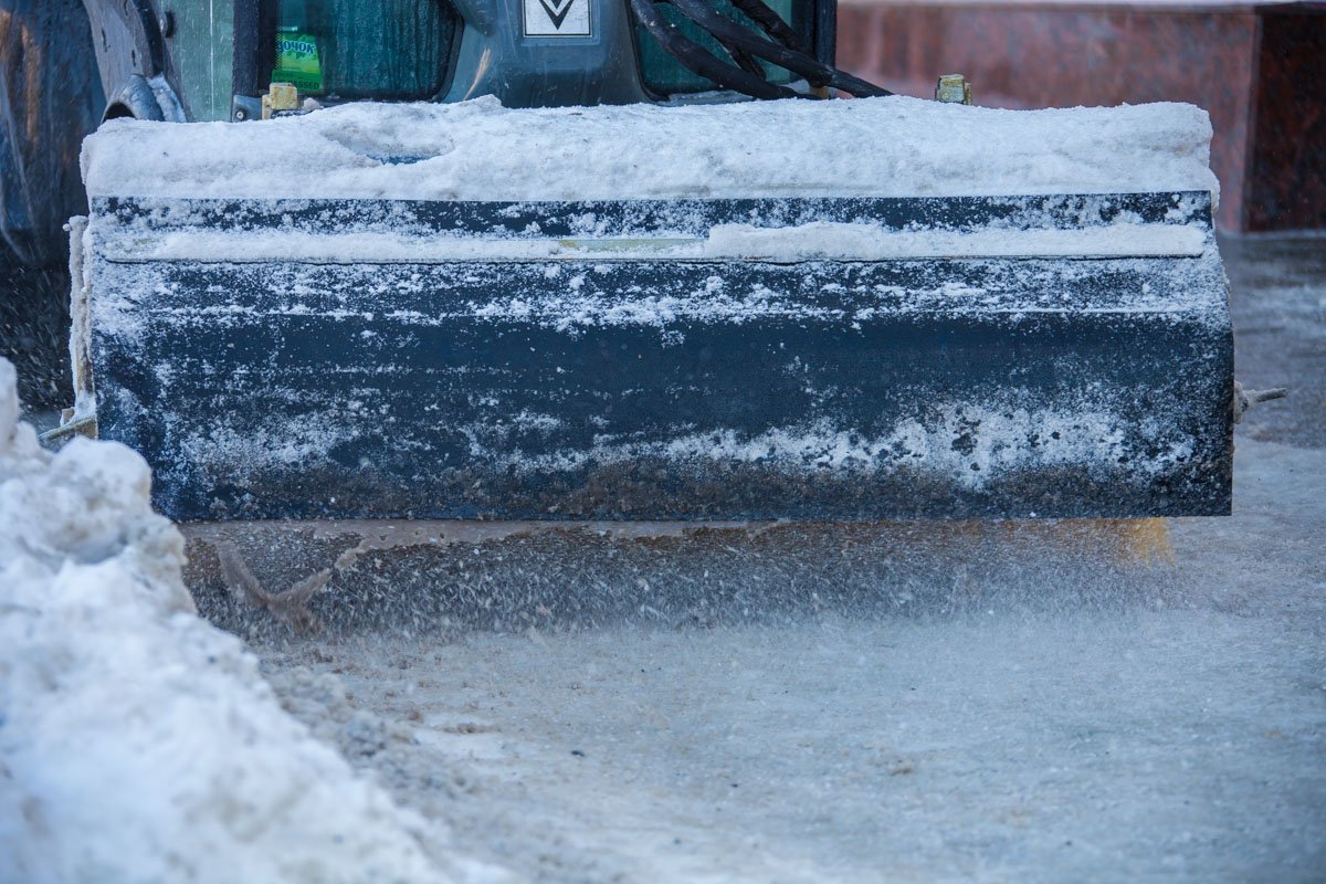 Техника убирает снег и посыпает его раствором Техника убирает снег и посыпает его раствором