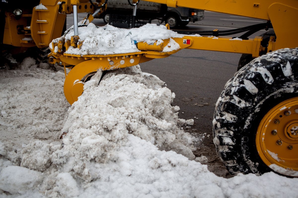 Автогрейдеры помогают выбивать снег, прижатый к бордюрам и заборам Автогрейдеры помогают выбивать снег, прижатый к бордюрам и заборам