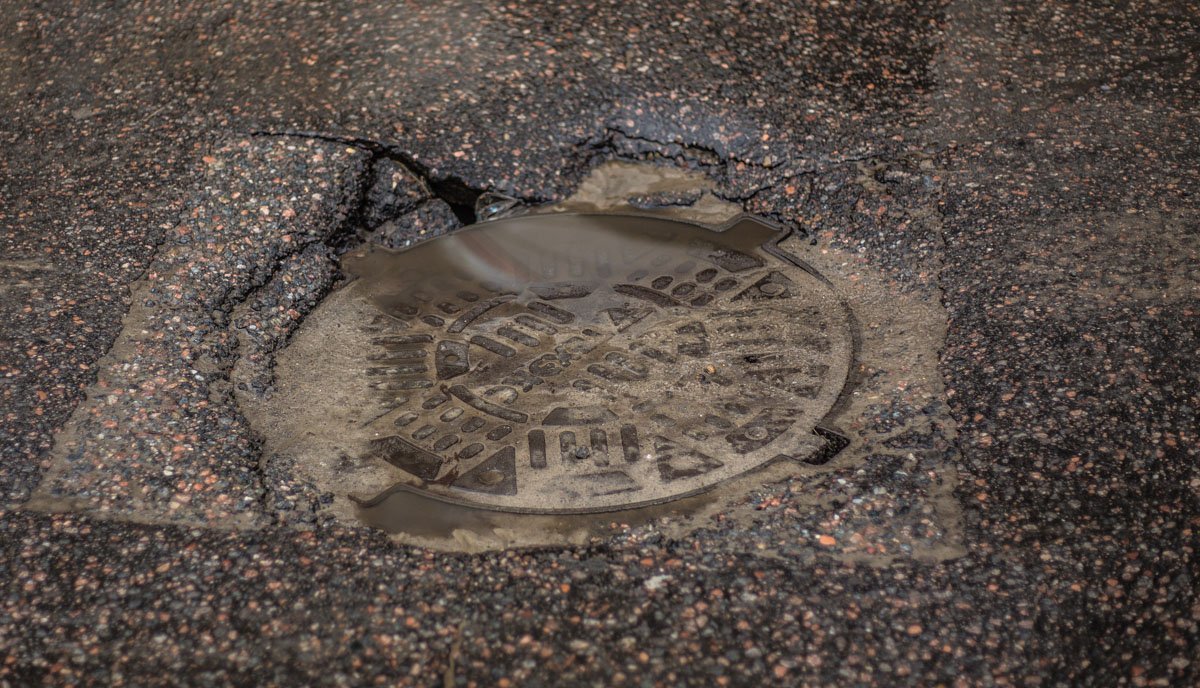Асфальт возле люка начал проваливаться