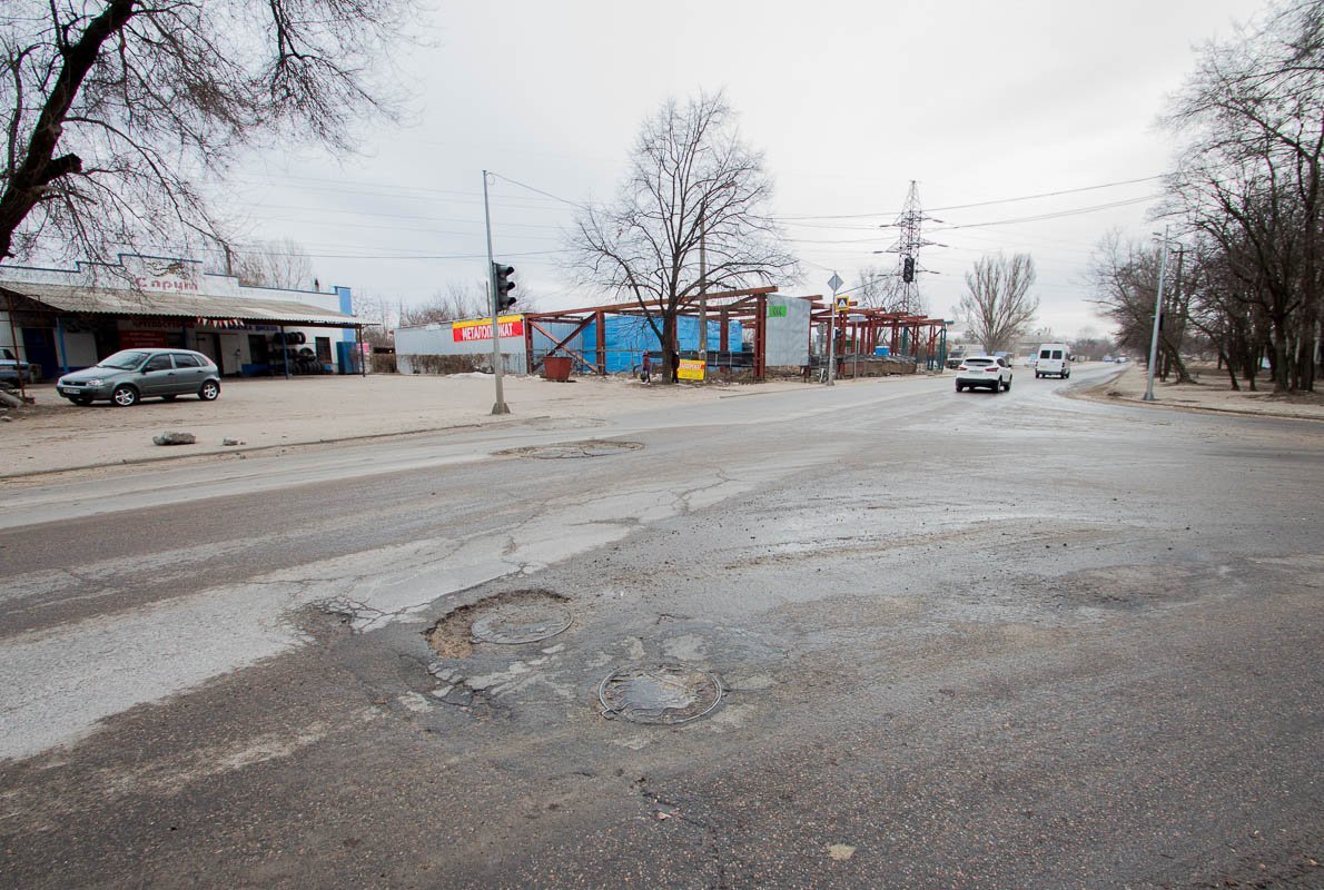 Пару люков уверенно "уходят" под землю вместе с асфальтом