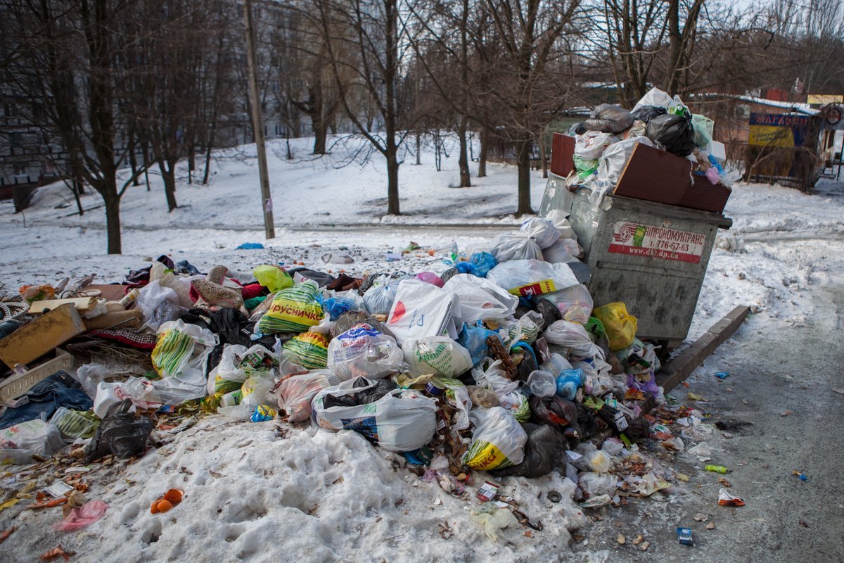 Мусорный бак, расположенный на склоне, усеял двор отходами