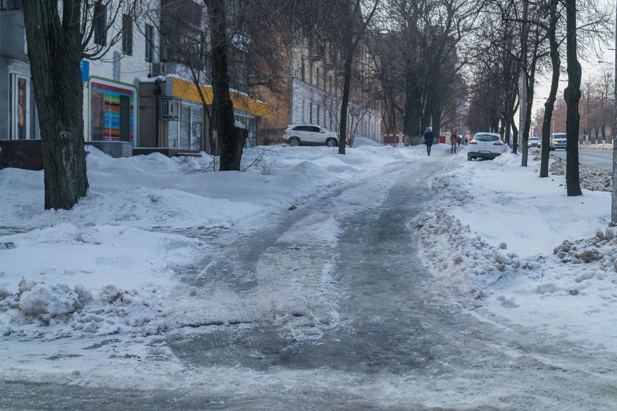 На "темной" стороне тротуара все еще лежит снег