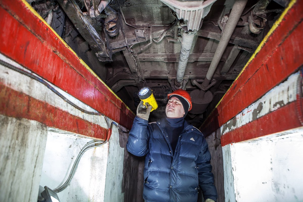 В смотровой яме механики проверяют техническое состояние маршрутки В смотровой яме механики проверяют техническое состояние маршрутки