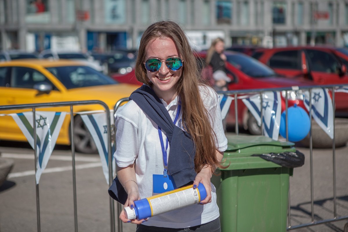 Организатор помогает деткам пополнить запас краски