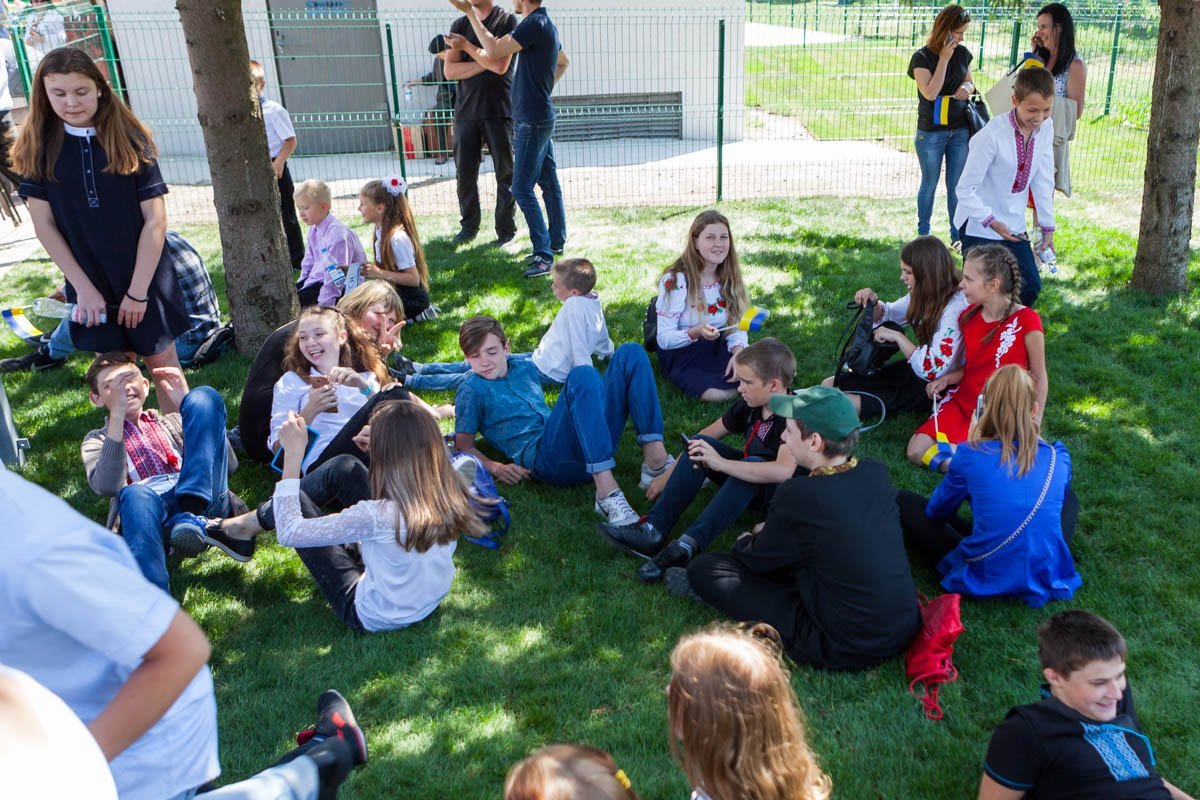 В конце мероприятия малыши отдыхали на газоне, расположившись в тени нескольких деревьев