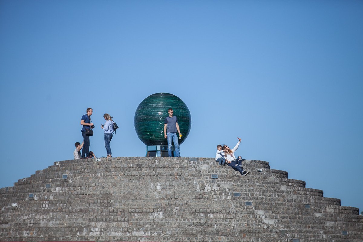 Мама с ребенком фоткаются на фоне папы