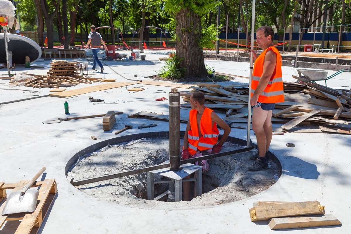 Рабочие закончили бетонные работы и работают с каркасами игровых объектов