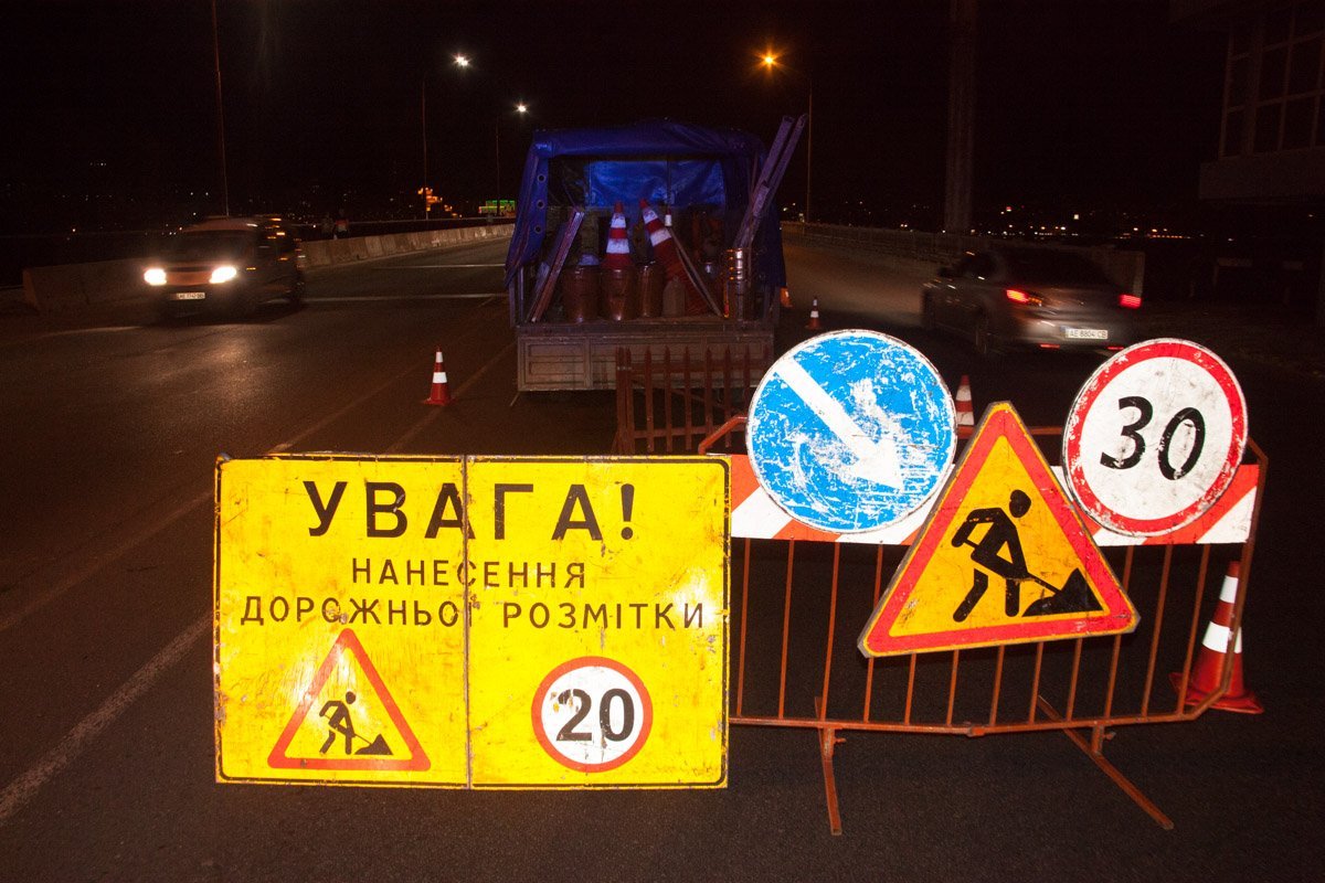 На мосту сотрудники коммунальных служб рисуют временную разметку На мосту сотрудники коммунальных служб рисуют временную разметку