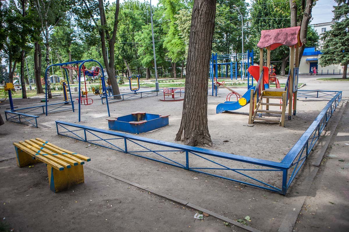 Детская площадка ограждена небольшим забором
