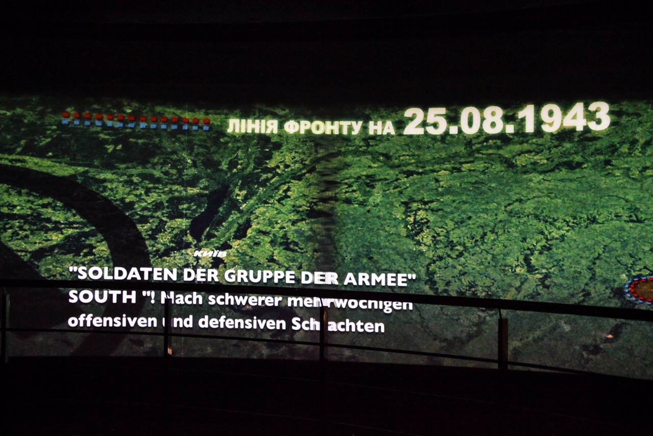 На огромном экране показывается документальное кино