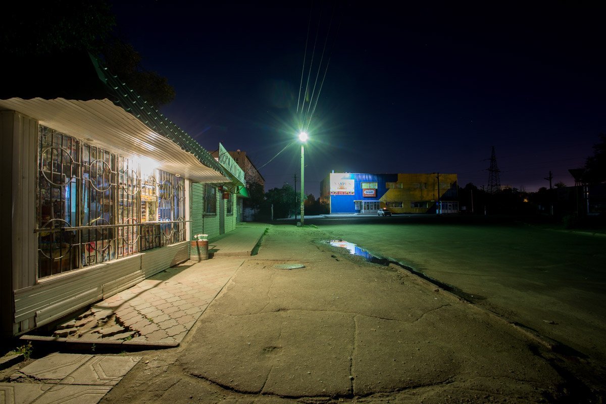 Зеленый свет фонаря освещает улицу