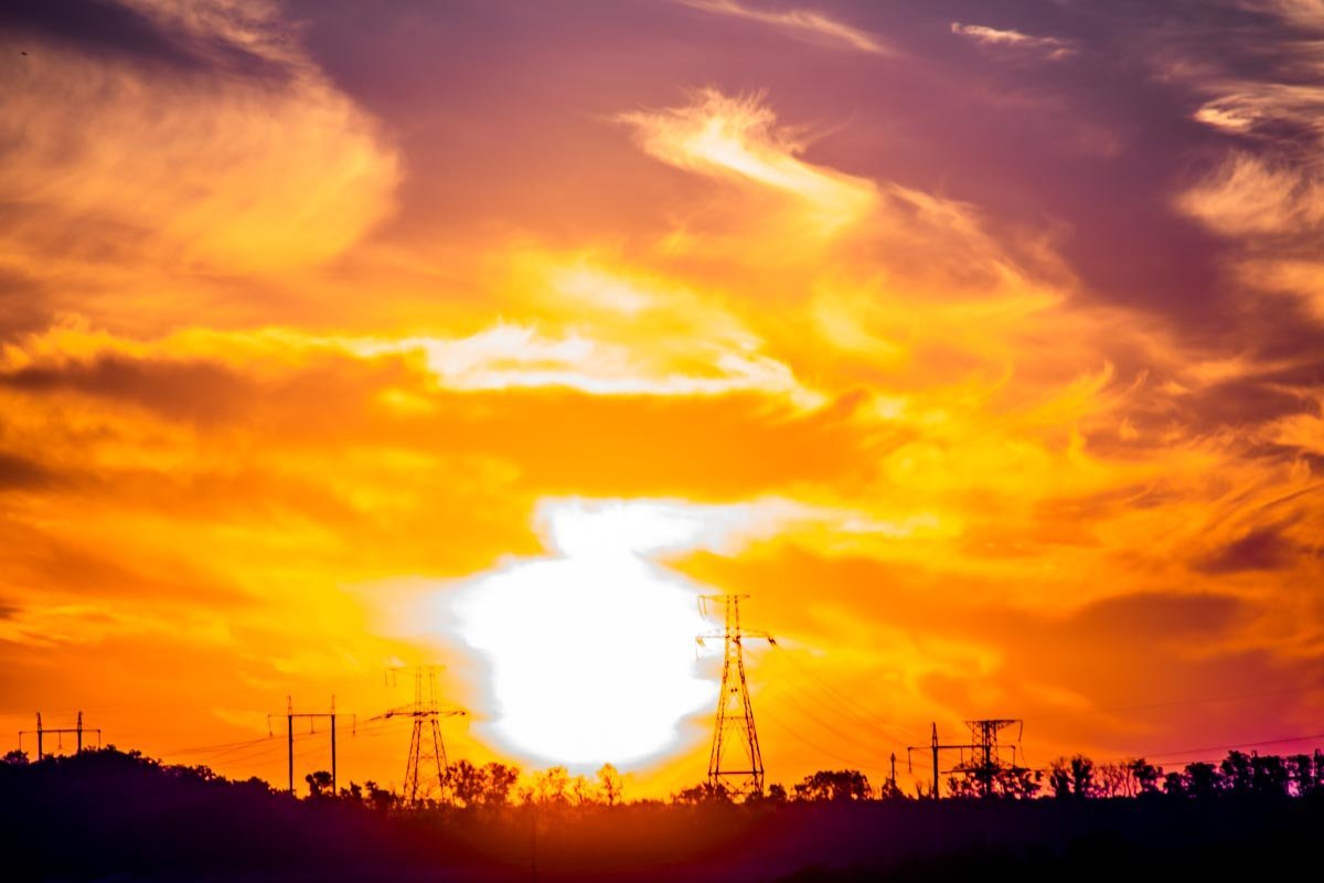 Солнце пробирается сквозь густые облака, освещая округу 