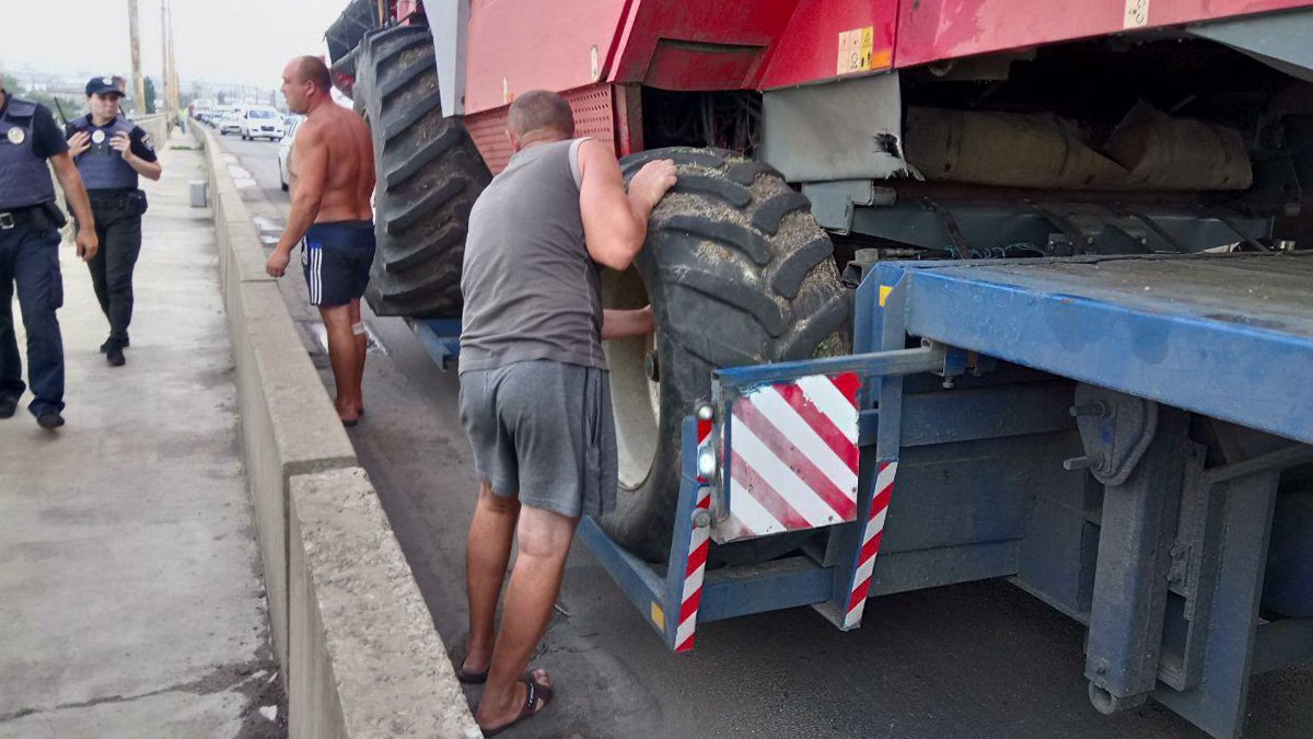 Водитель фуры спустил колеса комбайна, чтобы "протиснуться" в металлическую арку