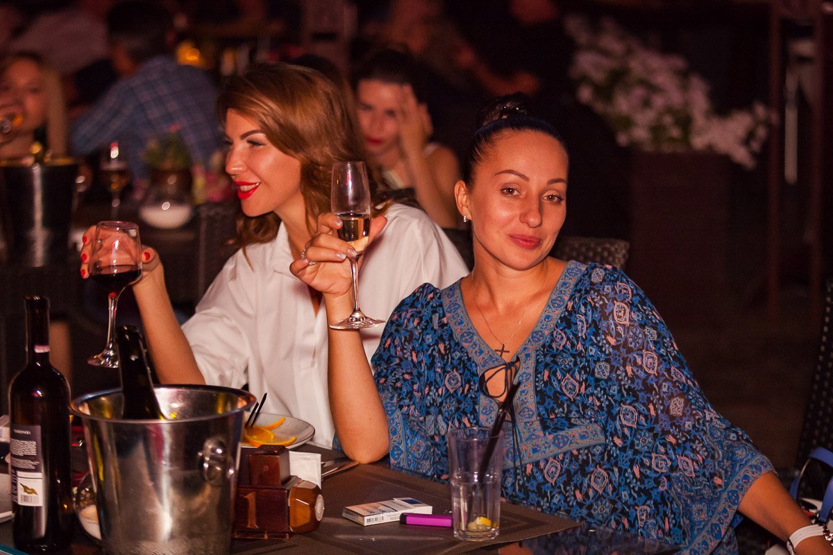 Большинство гостей расслаблялись за бокалом вина