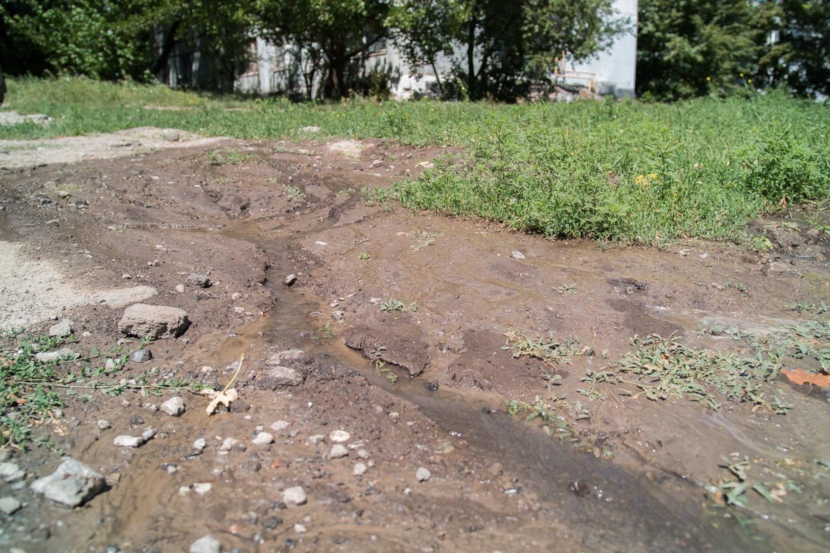 Маленький, но уверенный ручеек постепенно заливает дорогу на улице Выборгской