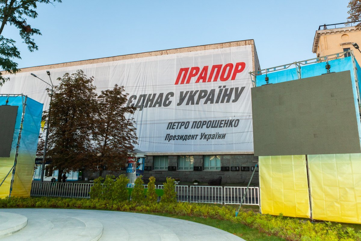 На административном здании висит большой плакат в честь Дня Государственного Флага На административном здании висит большой плакат в честь Дня Государственного Флага