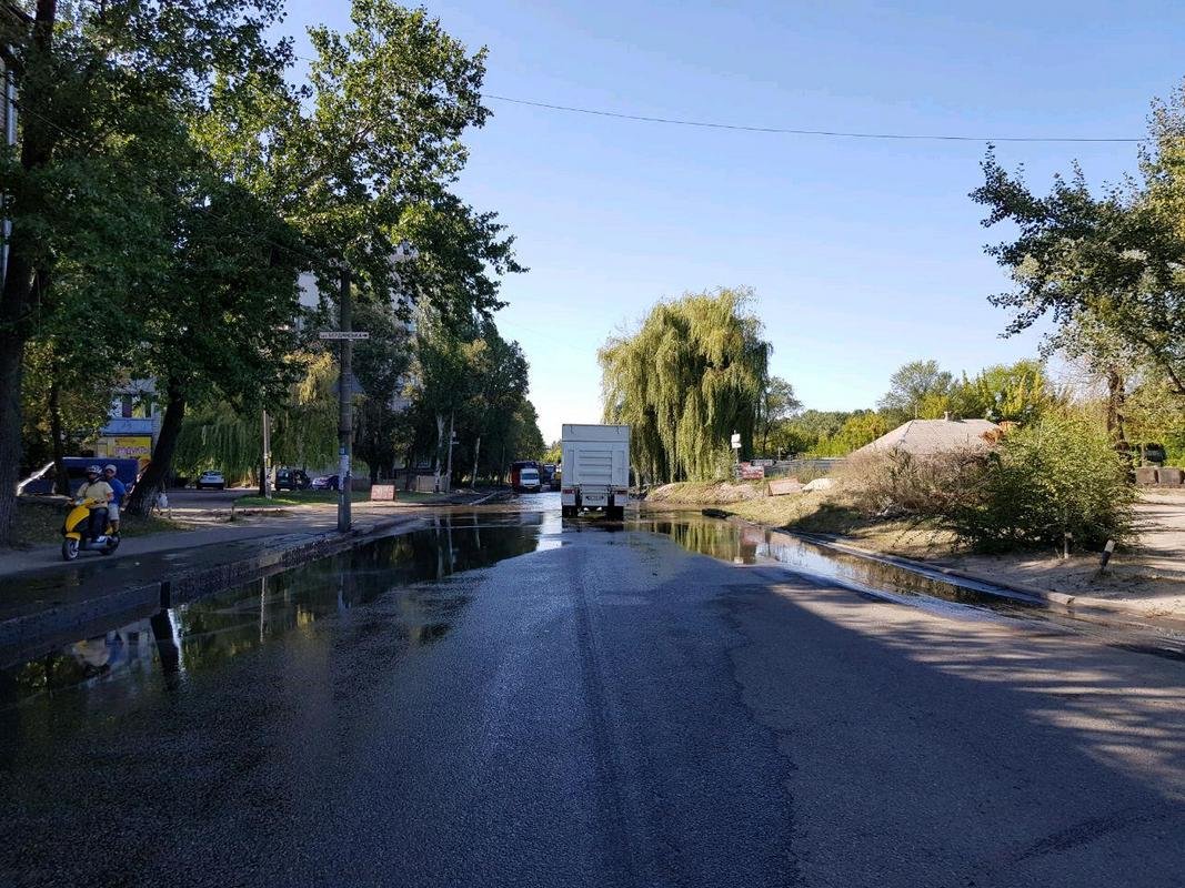 Владельцы двухколесного транспорта объезжают лужи по тротуару Владельцы двухколесного транспорта объезжают лужи по тротуару