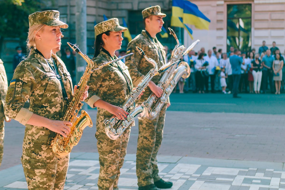 Девушки в военной форме, держащие музыкальные инструменты в руках выглядят обворожительно