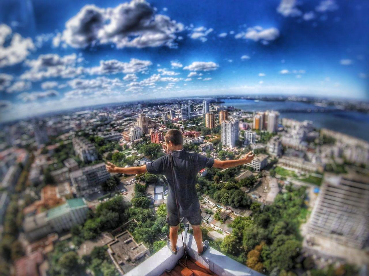 Парень взбирается на крыши вместе с друзьями