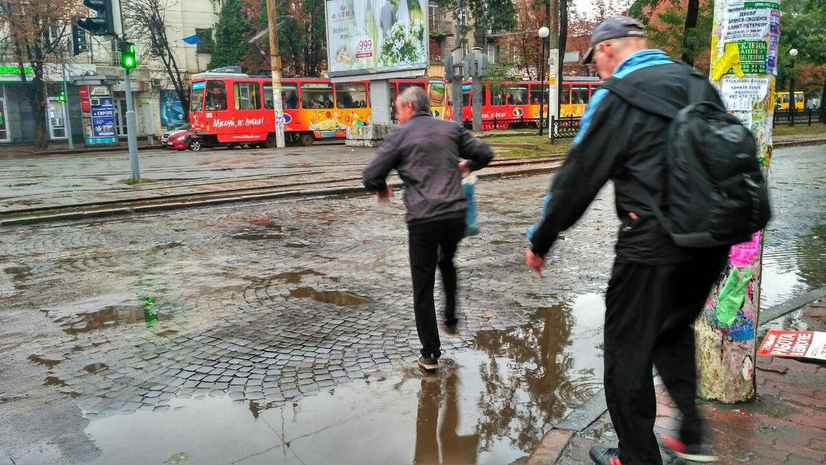 Люди пытаются обойти лужи