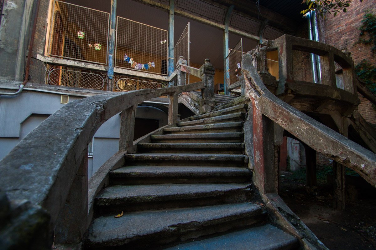 Акцентирует лестницу причудливое ограждение в виде кривых линий и небольшие пилоны с декоративными вазонами