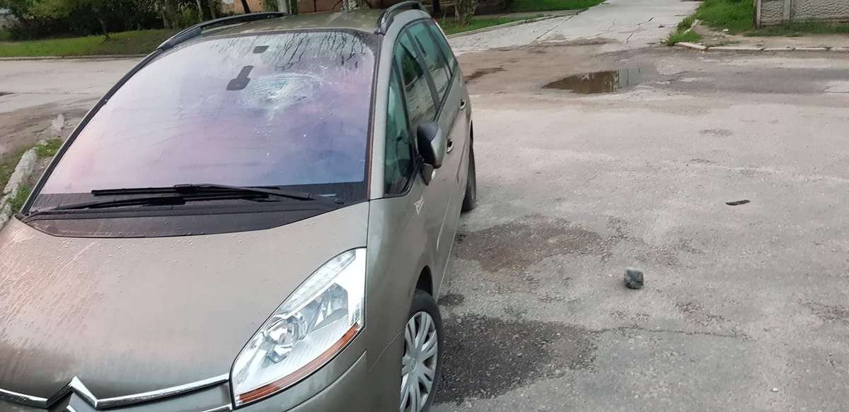 Вероятно, мужчина бросает камни в лобовое стекло автомобилей