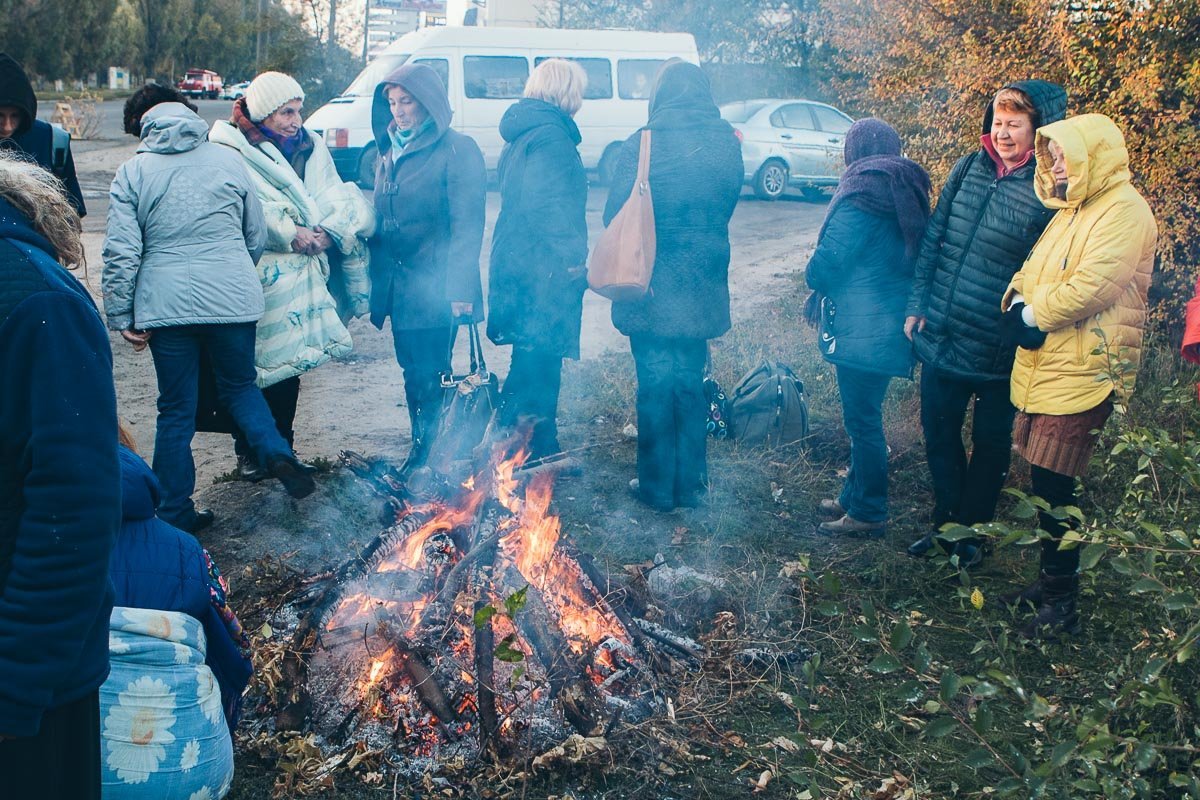 Чтобы не замерзнуть, люди развели костер и укутались в пледы Чтобы не замерзнуть, люди развели костер и укутались в пледы