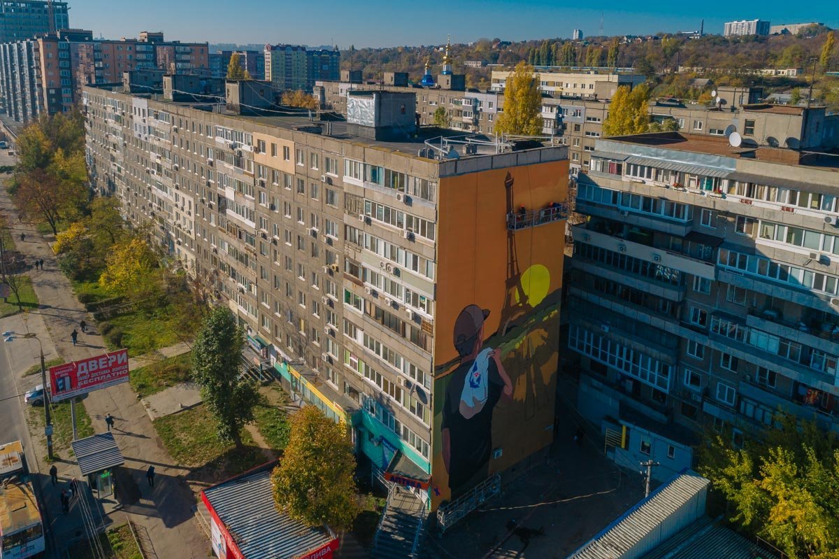 Он представляет собой молодого гастарбайтера, который задумчиво смотрит на Эйфелеву башню Он представляет собой молодого гастарбайтера, который задумчиво смотрит на Эйфелеву башню