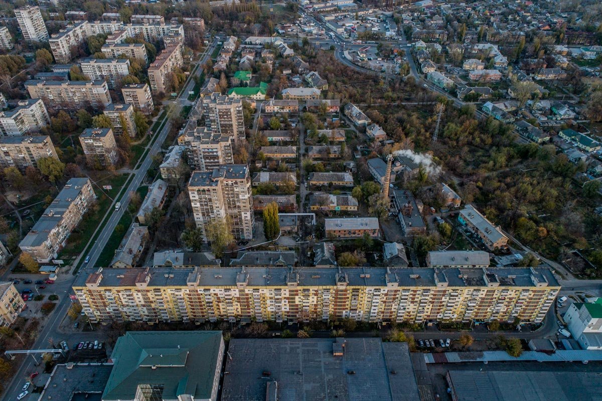 Маленькими домики словно спрятали в тени многоэтажек
