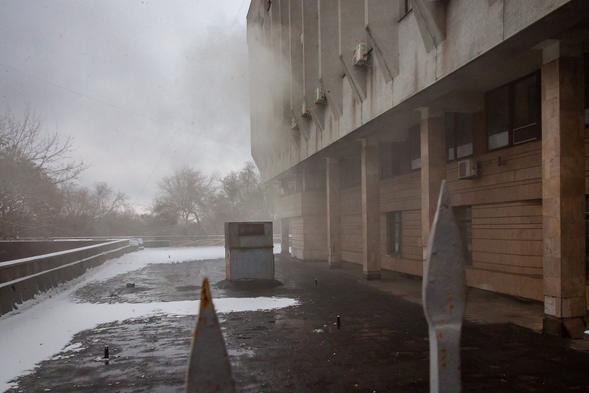 Из окна здания выбросили дымовые шашки