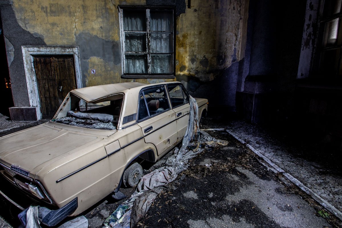 Брошенное авто рядом с брошенными бетонными конструкциями