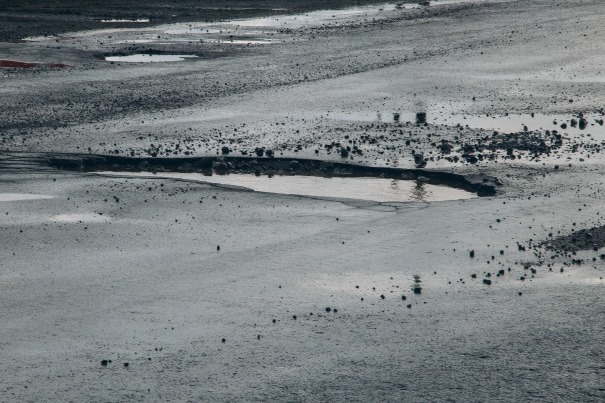 Покрытие, по которому ежедневно двигаются сотни машин, состоит из ям и выбоины