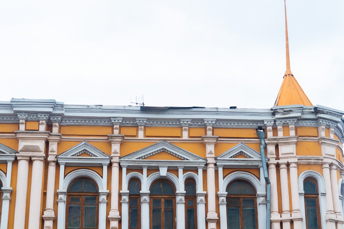 С крыши одного из зданий на Европейской площади свисает два металлических листа