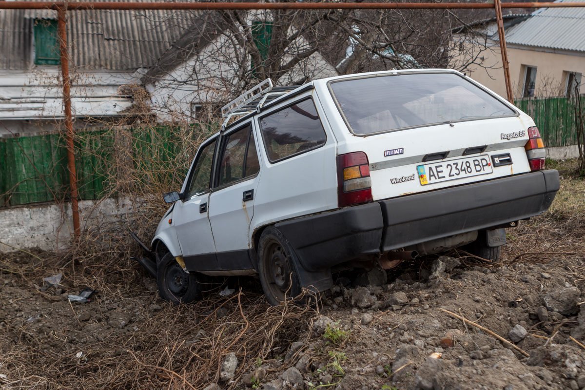 Спускаясь с горки, Fiat влетел в насыпь и врезался в забор дома