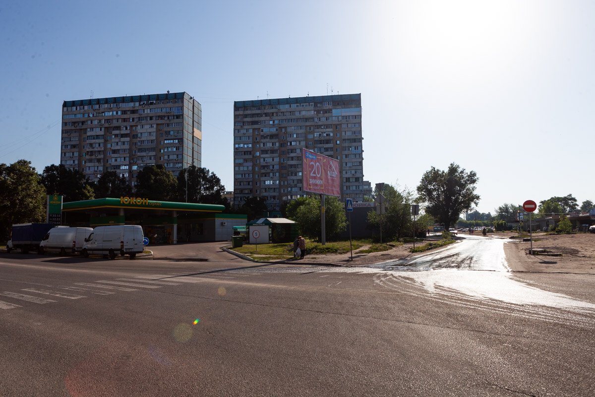 Залитая водой улица заметно усложняет жизнь пешеходам, которым приходится обходить значительную часть дороги