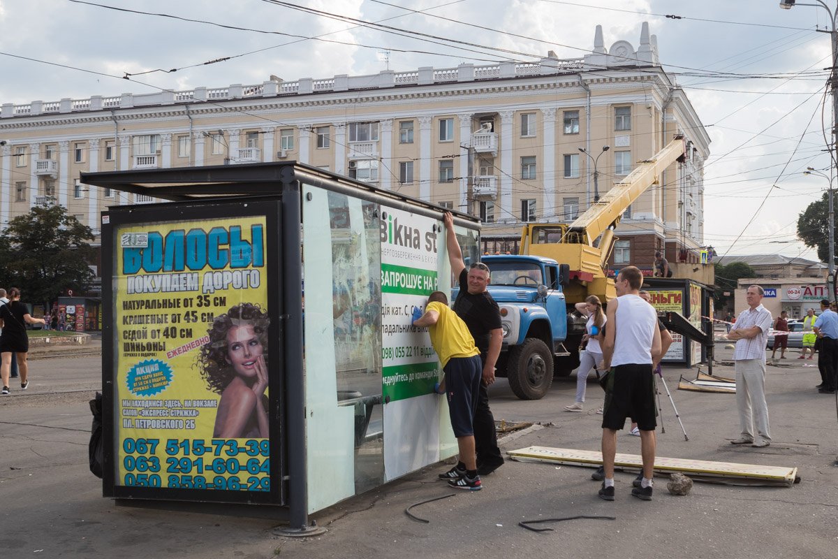 Коммунальщики вставляют стекло в павильон 