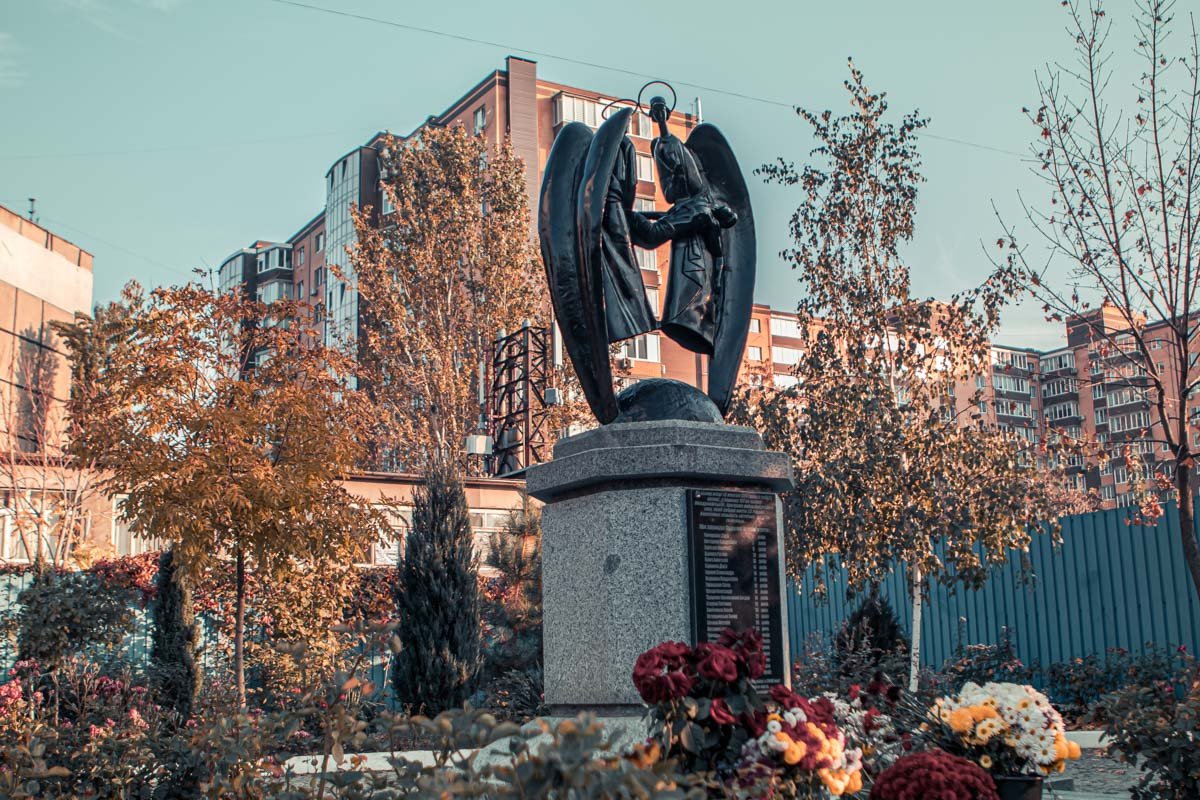 Во дворе церкви установлен памятник - два ангела, держащих в руках юношу
