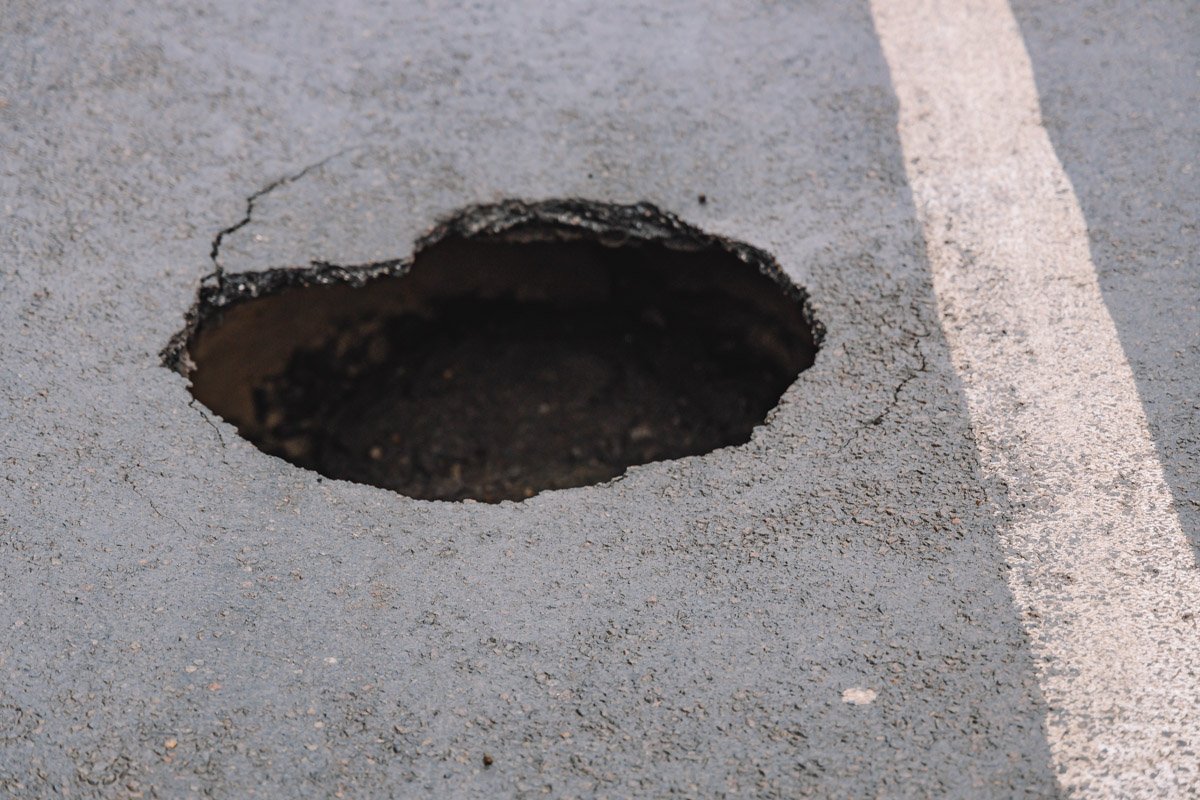 Дыра образовалась под дорожным покрытием в следствие протечек вдоль коллектора Дыра образовалась под дорожным покрытием в следствие протечек вдоль коллектора