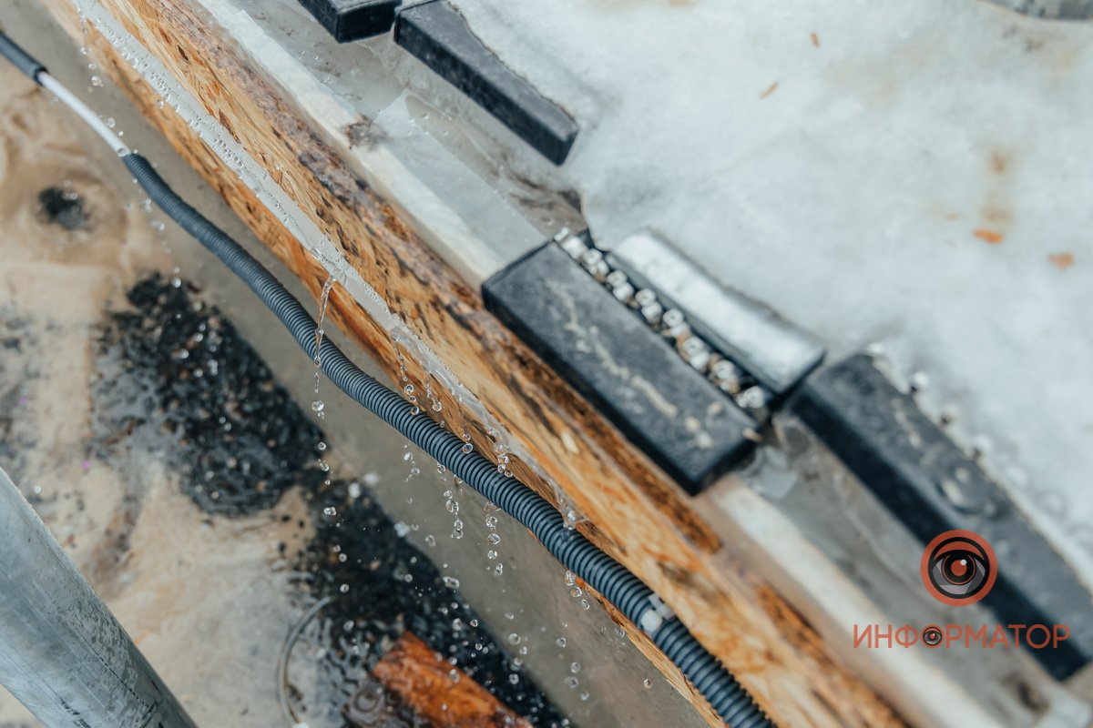 На асфальт стекает вода